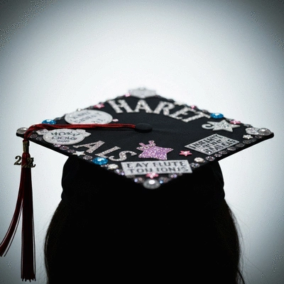 Close-up of a creatively decorated graduation cap with personalized messages